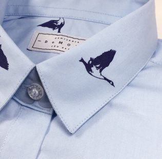 Camisa azul clara em algodão com estampa de gaivotas azul marinho.